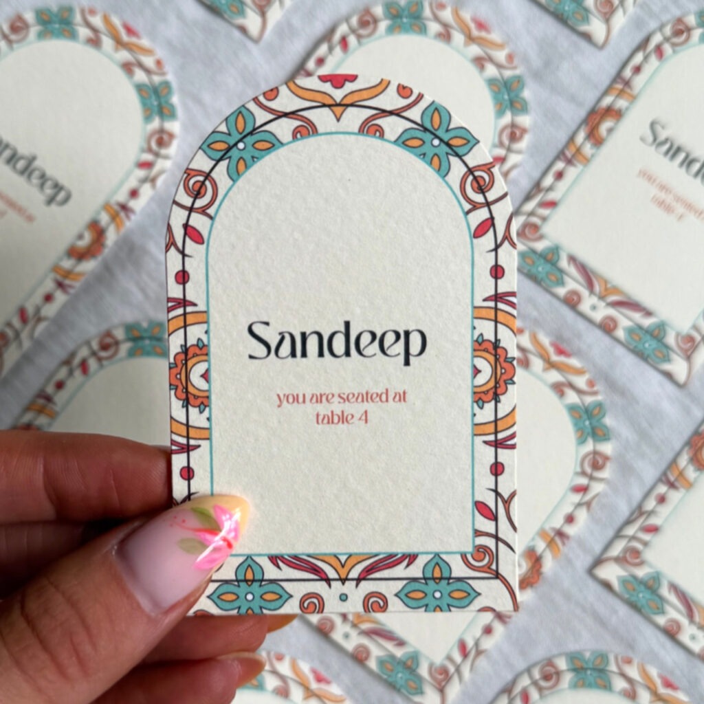 Upper arch wedding place card name with red, orange and teal colours 