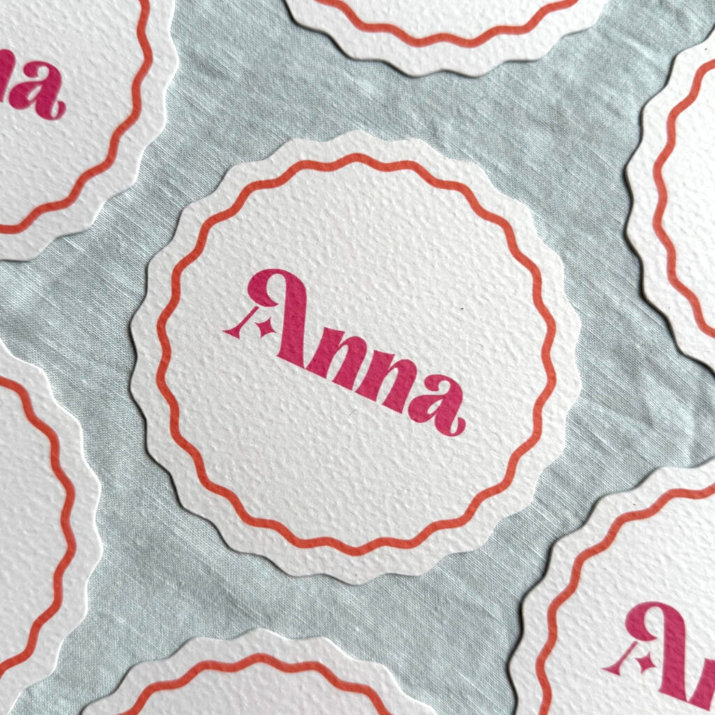Wavy circle place name with orange wavy line and bold pink text